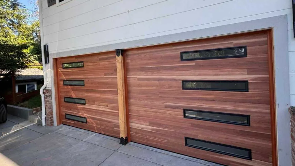 Close exterior view of a panelled garage door beside a hose reel